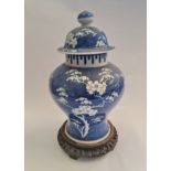 A large cherry tree blue and white ginger jar on wooden base.approx 38cm.