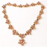 A Georgian style pink topaz and seed pearl necklet, comprising nineteen pink topaz flower clusters