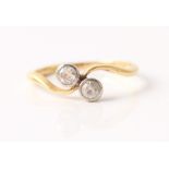 A two stone ring, set with a round brilliant cut diamond measuring approx. 0.10ct, and a round cut