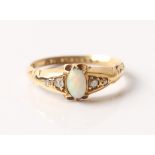 A hallmarked 18ct yellow gold opal and diamond ring, set with a central oval opal cabochon flanked