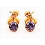 A pair of synthetic colour change sapphire drop clip-on earrings, with scroll and leaf design,