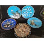 Five blue cloisonné plates with various designs.