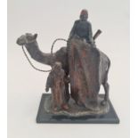 A painted spelter table lighter the carpet seller camel with two Arabs.