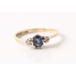 A hallmarked 9ct yellow gold sapphire and diamond three stone ring, set with a central oval cut