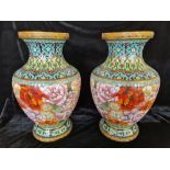 A pair of cloisonné vases with floral design.