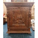 A heavily carved oak cupboard base .