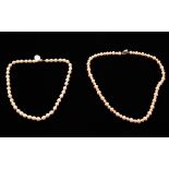 A string of alternating white and peach cultured pearls, length approx. 18 and a string of white