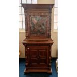 A heavily carved oak cupboard with lead glazed top.