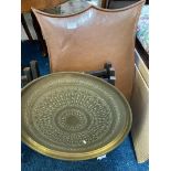 A copper fire screen, copper bowl and brass topped table.