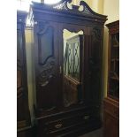 An Edwardian single mirror door wardrobe with a pierced top.