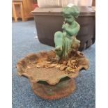 A cast iron garden cherub birdbath.