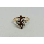 A hallmarked 9ct yellow gold garnet and diamond ring, set with three baguette cut garnets flanked to