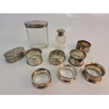 A collection of hallmarked silver, to include various napkin rings, a glass pepperette, a dressing