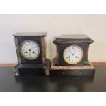 Two black slate mantle clocks with red and cream marble.