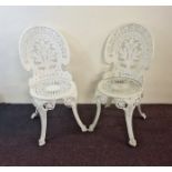 A set of four white painted metal garden chairs.