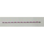 A hallmarked 9ct white gold pink stone and diamond bracelet, set with twelve oval cut pink stones,