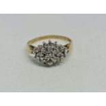A hallmarked 9ct yellow gold diamond cluster ring, the tiered design set with round brilliant cut