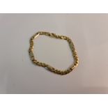 A curb link bracelet, with alternating length links, yellow metal stamped with Arabic numerals,