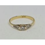 A diamond ring, set with a principal round brilliant cut diamond, measuring approx. 0.20cts. flanked