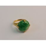 A green hardstone ring, set with a round green hardstone cabochon, with engraved shoulders,