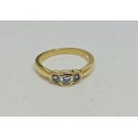 A three stone diamond ring, bezel set with three graduated round brilliant cut diamonds, total