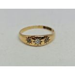 A hallmarked 18ct yellow gold three stone diamond ring, star set with three round cut diamonds,