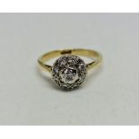 A diamond cluster ring, set with a central round brilliant cut diamond surrounded by eight round
