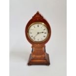 A mahogany balloon shaped mantle clock with inlaid border and lyre to front. 27cm.