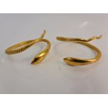 A pair of snake design bangles with textured metalwork bodies, stamped with Arabic numerals.