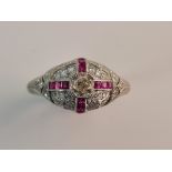 A stamped PLAT cluster ring, central diamond approx. 0.40cts, with baguette rubies, ring size L 1/2,