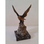 A cold painted spelter eagle on rocks desk lighter on marble base.
