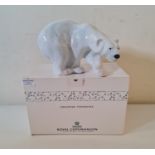 A large Royal Copenhagen polar bear walking with box.