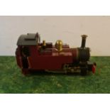 A gauge 1 model train engine red and black.