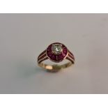 A stamped 14k diamond ring approx. 1.00cts, surrounded by a border of baguette rubies flanked to