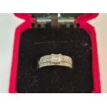 A diamond ring, set with a central princess cut diamond, measuring approx. 0.50ct, to a three band