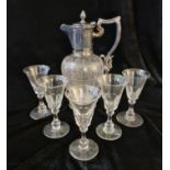 An engraved claret jug with a set of five wine glass.