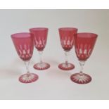 A set of four hand blown ruby red wine glasses.