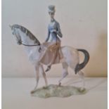 A large Lladro figure of lady riding horse.