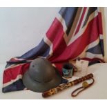 A WW1 British helmet Union Jack flag 1919 peace tin cup and a 1914-1918 truncheon.