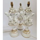 Three porcelain table lamps with cherubs to top.