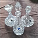 Three cut glass decanters with stoppers.