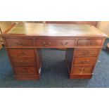 A mahogany twin pedestal desk with green leather top.