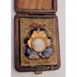 A miniature clock, housed in enamel floral design A/F, (in box)