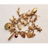 A hallmarked (on heart lock )9ct yellow gold link charm bracelet, with approximately 16 various