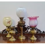 Four brass oil lamps and shades.