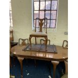 A walnut extending dining table together with four chairs.