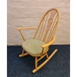 An Ercol rocking chair with green pad.