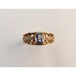A 9ct gold fancy fret work ring set with pale blue sapphire stone and 8 diamonds to shoulders.