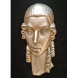 An art deco wall mask of lady with silver finish.