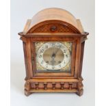 A walnut cased table clock with brass and silvered face. 36cm.